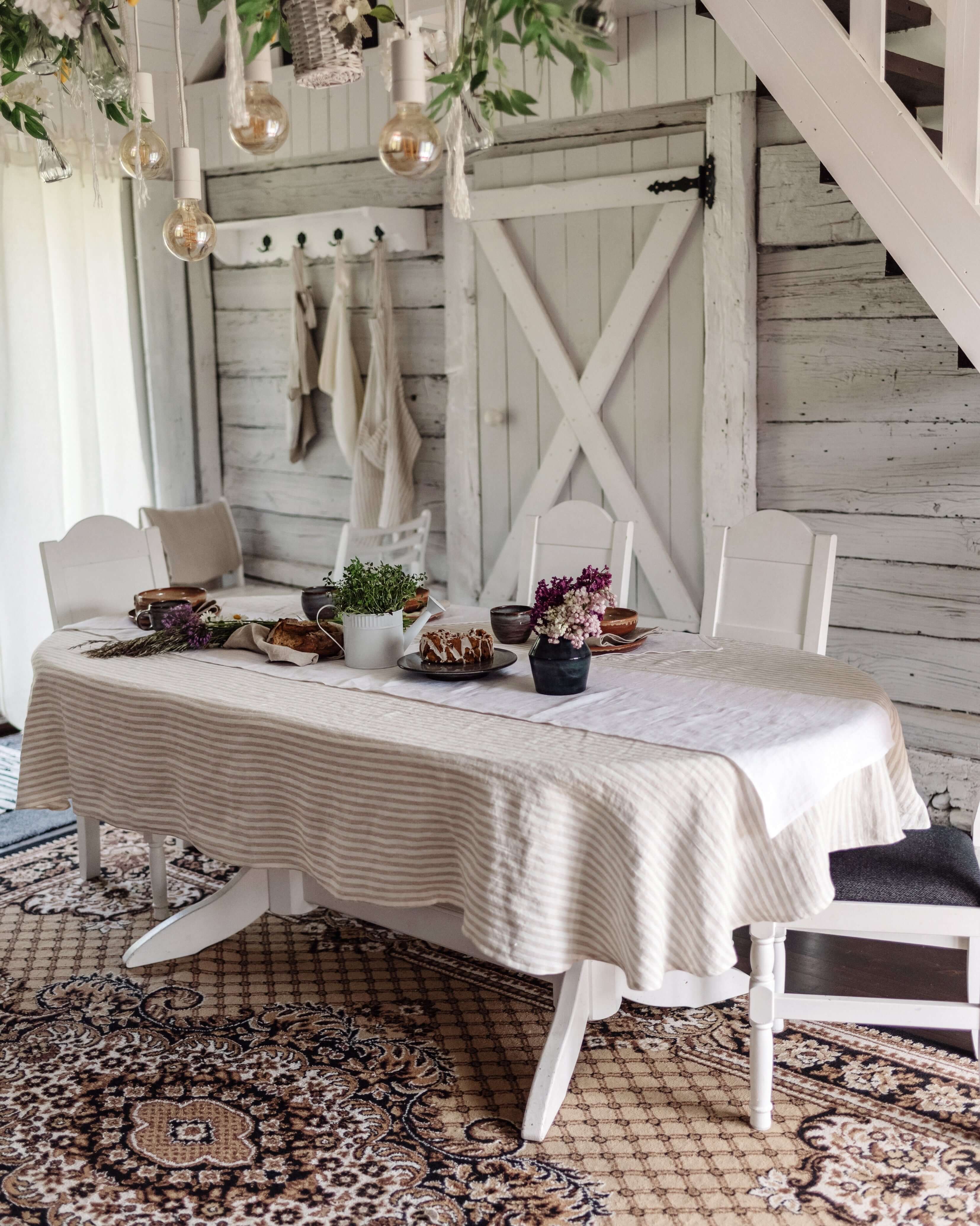 Oval linen tablecloth on dining table, natural tone, top view