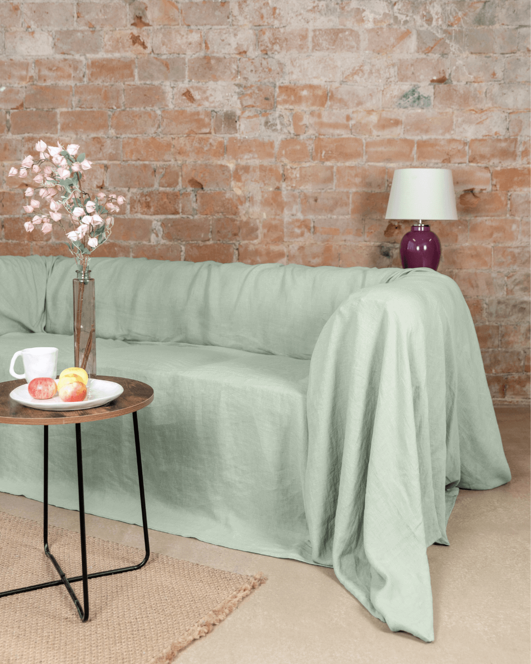 Sage green linen L shaped sofa cover draped on sofa in living room