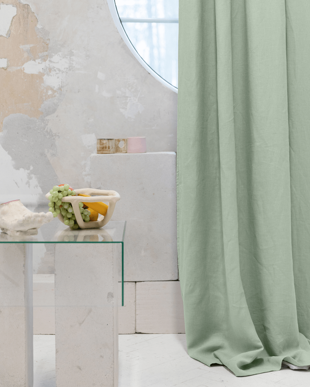 Sage green linen blackout curtains with styled table, interior detail