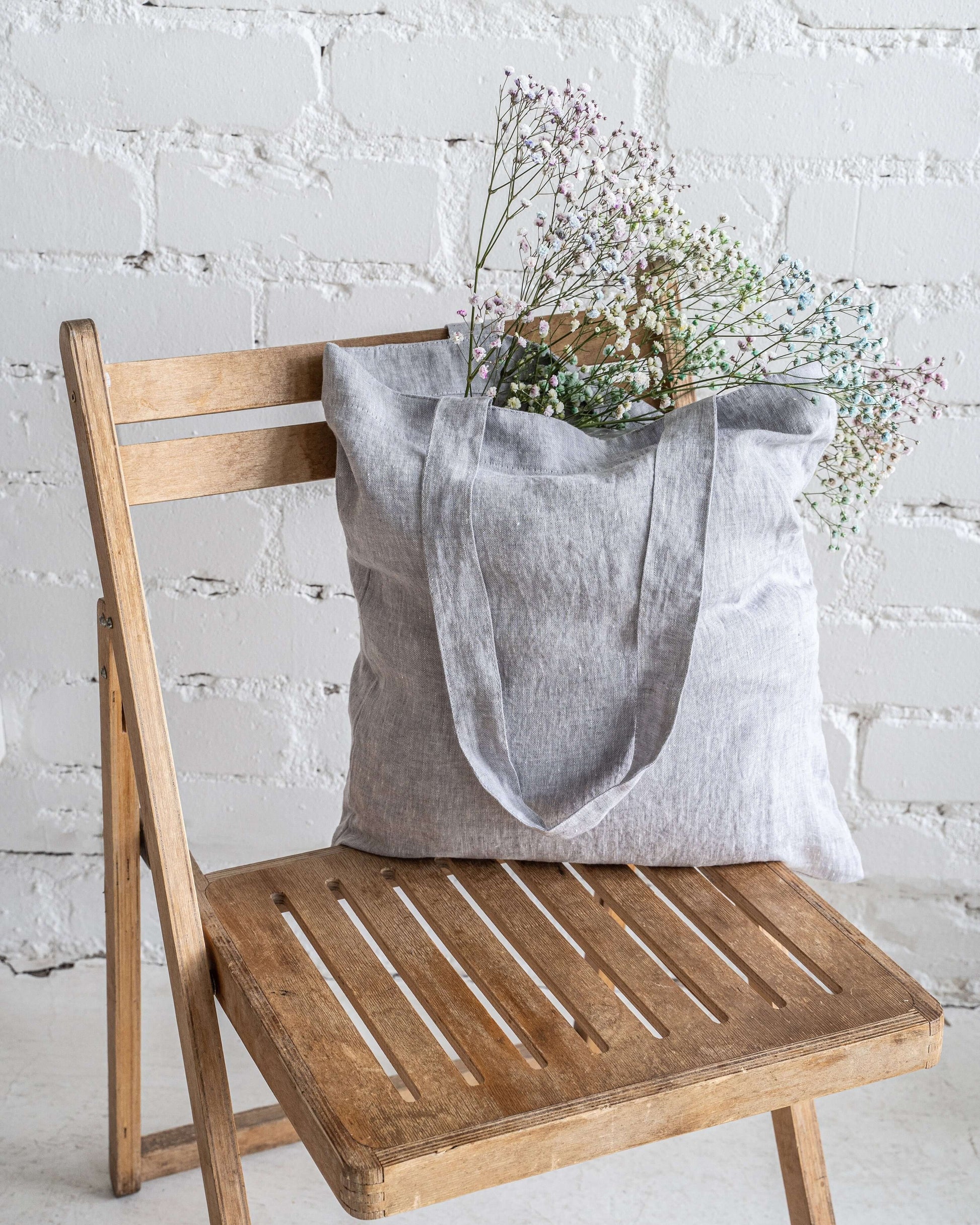 Woman carrying linen tote bag, showing size and proportion